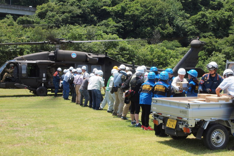 (写真)補給品受領訓練で米陸軍のヘリから支援物資を運ぶ