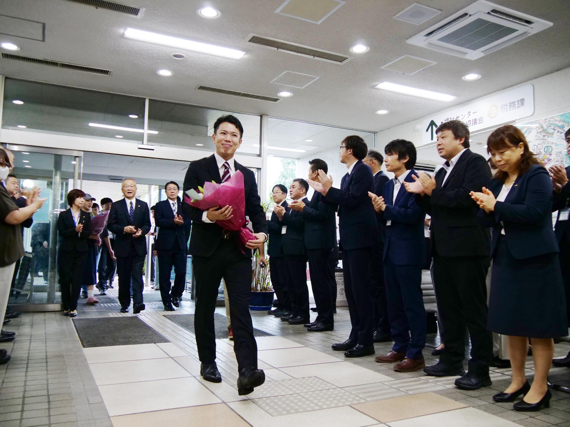 （画像）初登庁で支援者や町職員に出迎えられる茅町長