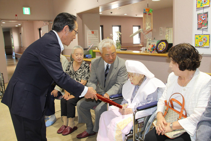 （写真）小野澤町長からお祝いの額を受け取る小野澤さん