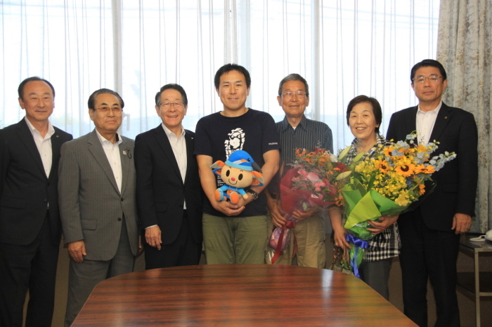 （写真）荻田さんとご両親、小野澤町長、馬場県議会議員、吉川副町長、佐藤教育長の集合写真