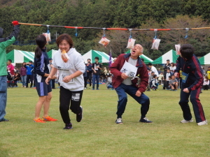 （写真）「パン食い競争」に参加する大人たち