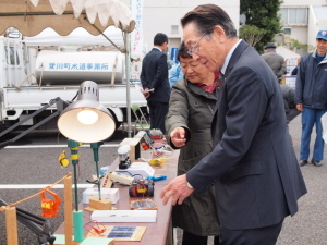 （写真）太陽光で動くおもちゃを見学する小野澤町長