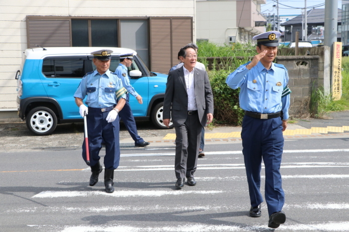 （写真）巡視する小野澤町長と河辺署長を案内する柳川交通指導隊長