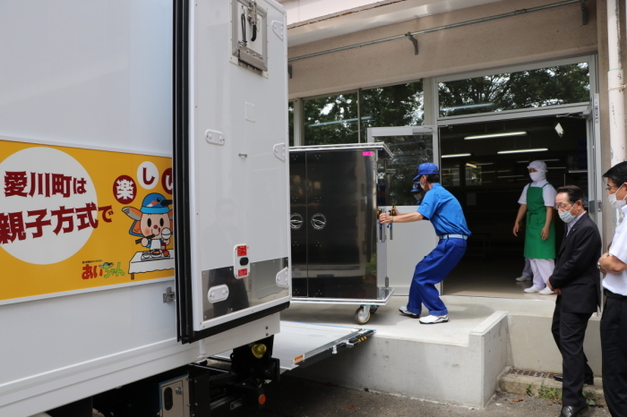 （写真）トラック配送の様子を視察する小野澤町長