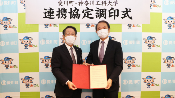（写真）協定書を持って並ぶ小野澤町長と小宮学長
