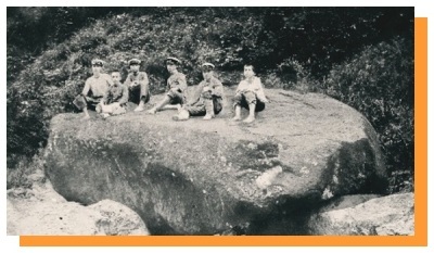（写真）石小屋の巨石の上に座る子供たちの古写真